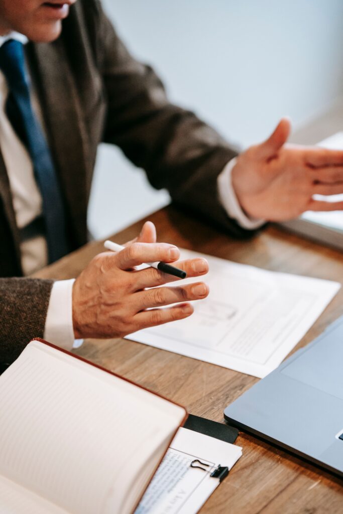 pexels-photo-6326394-6326394 Professional discussing documents over a wooden table in an office setting.